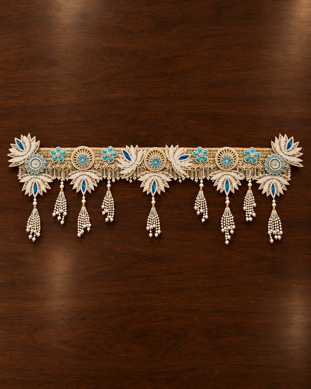Full length of the 40 inch handmade pearl lotus toran laid flat, with 9 pearl tassels and lotus pendants