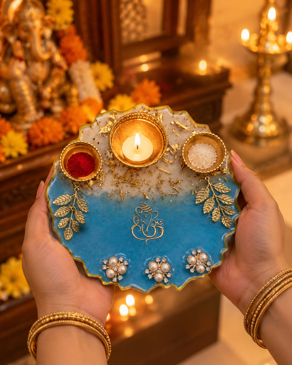 Hands holding the 6-inch blue Ganesha pooja thali during aarti