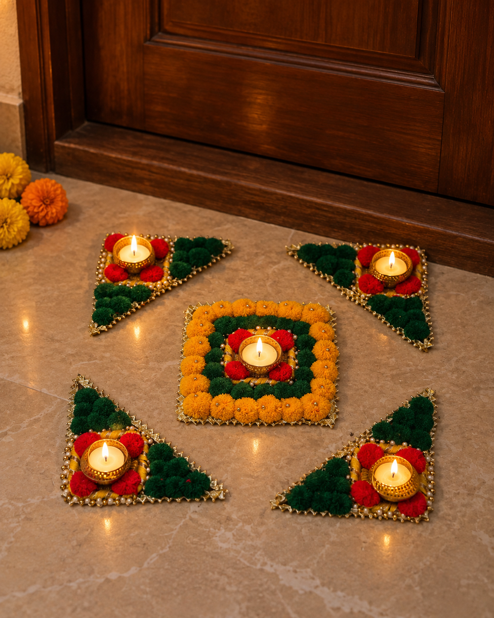 Reusable marigold and green rangoli set with five lit tealights at a home entrance on Diwali night