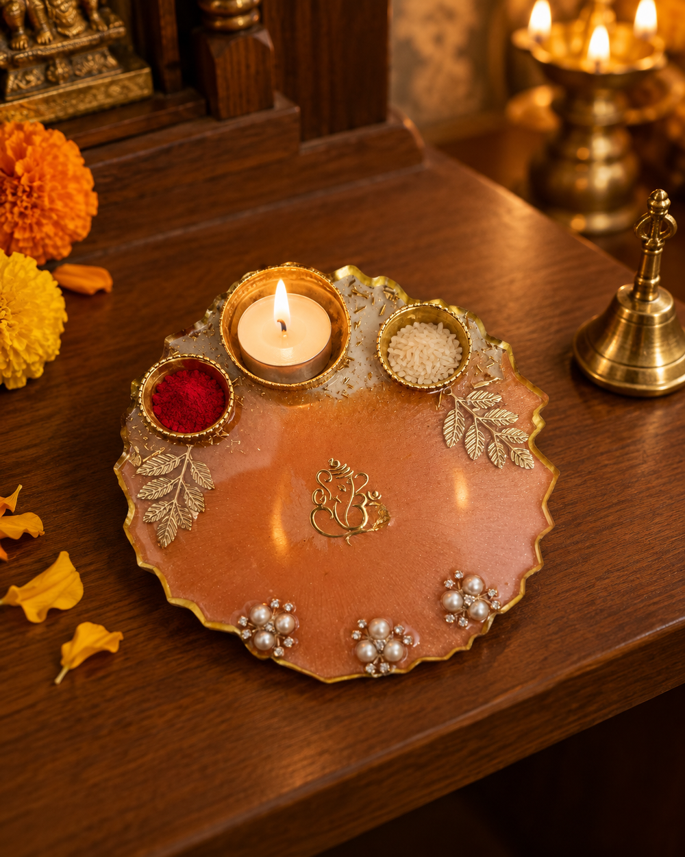 Peach and gold resin pooja thali with a lit tealight on a home mandir shelf