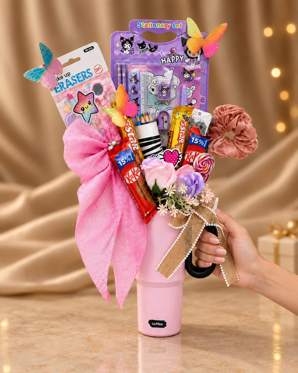 Pink tumbler birthday gift hamper held by its handle, showing its size
