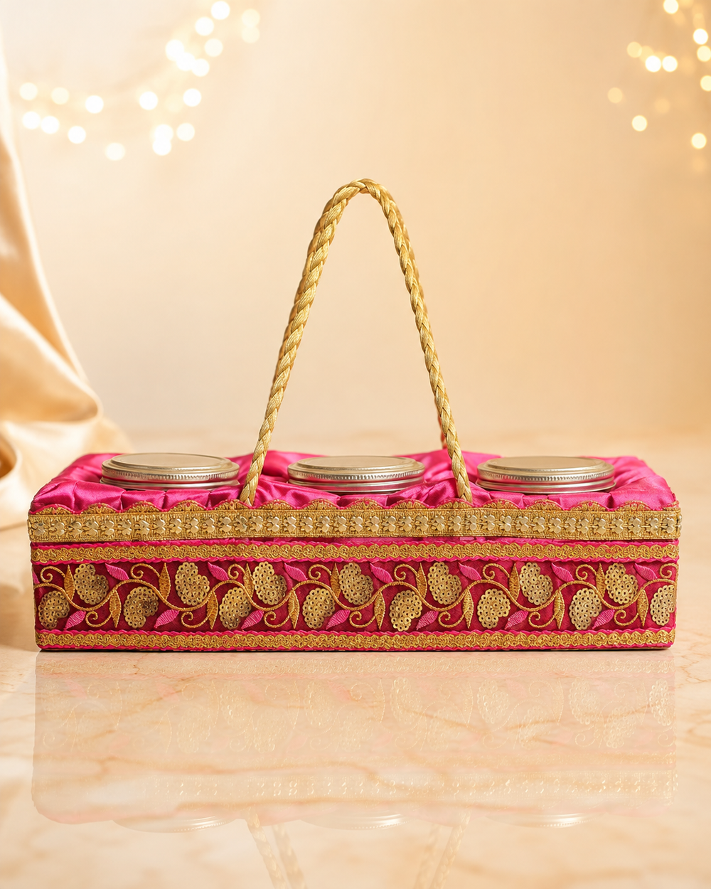 Side view of the premium pink dry fruit gift box showing the full gold zari embroidered panel and rope handle