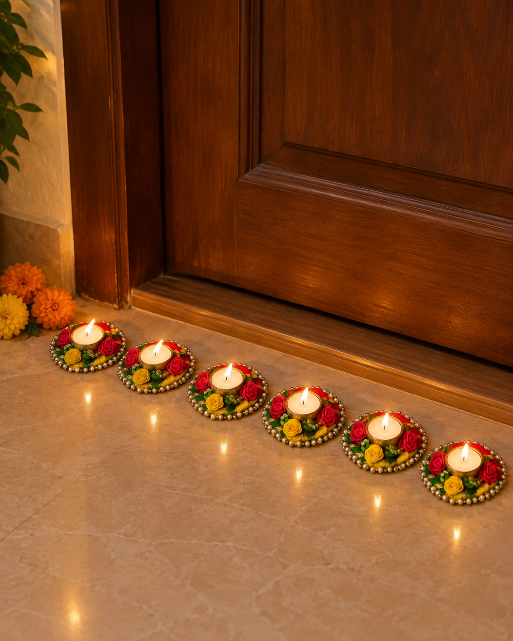 Pack of 6 rose garland tealight diyas lit along a home entrance on Diwali